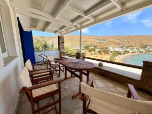 a balcony with tables and chairs and a view of the ocean at Aegean Big Blue -Rosalie Home in Tinos