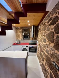 a kitchen with a stone wall at Mar De Pedra in Cangas de Morrazo