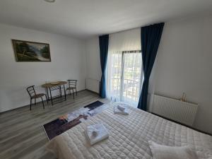 a bedroom with a bed and a table and chairs at NP Luxury Apartments in Novi Pazar +5 photos
