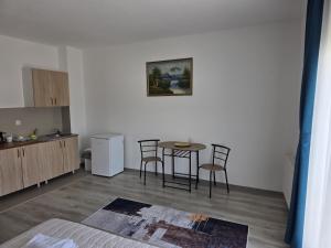 a kitchen with a table and chairs in a room at NP Luxury Apartments in Novi Pazar