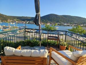 a balcony with two couches and an umbrella at seafront HOUSE LALA Vinišće in Vinišće