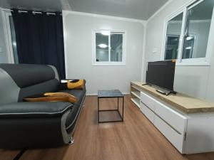 a living room with a chair and a television at KF Logement Wallis in Hihifo Airport +3 photos