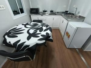 a kitchen with a black and white blanket on a table at KF Logement Wallis in Hihifo Airport