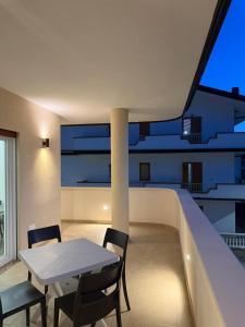 a room with a table and chairs on a balcony at Tropea Olympus Apartments in Santa Domenica