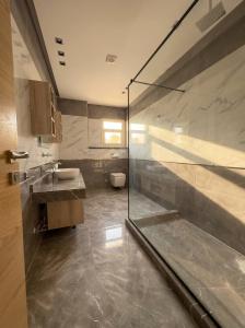 a bathroom with a shower and a sink and a toilet at Elite hotel in Sheikh Zayed +56 photos