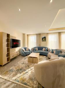 a large living room with couches and a tv at Elite hotel in Sheikh Zayed