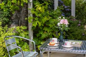 a table with a vase of flowers and tea cups at Penbontbren Luxury Bed and Breakfast in Aberporth