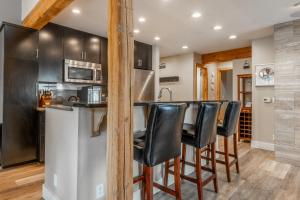 a kitchen with a bar with black leather stools at Western Slope Villa 22 in Mammoth Lakes