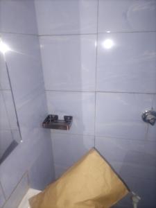 a bathroom with a shower with a yellow rug in it at Mtomo vision in Mtwapa
