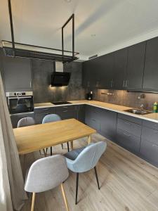 a kitchen with a wooden table and some chairs at Hillegård 6E in Lærdalsøyri
