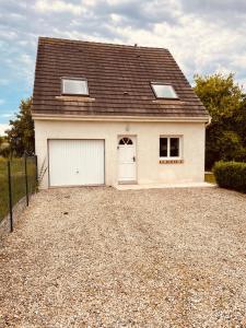 a house with a garage on a gravel driveway at La Guignicourtoise in Guignicourt