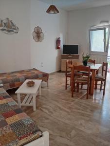 a living room with a couch and a table at Spacious Apartment Garden View Partial Seaview in Makry Gialos