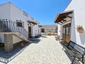 a courtyard of a house with chairs and stairs at B&B Il Baglio in Locogrande