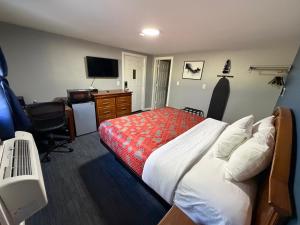 a bedroom with a bed and a desk with a computer at Chaplin Inn & Suites in Chaplin