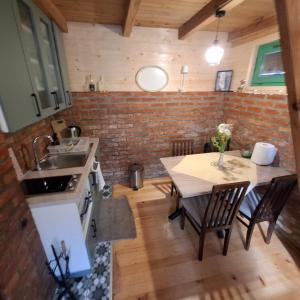 a kitchen and dining room with a table and a sink at Vikendica Breza in Zaovine