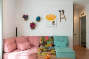 a living room with a pink couch and two chairs at Casa Naranjo - Plaza Mayor Almagro in Almagro +32 photos