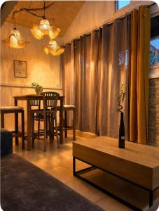 a living room with a table and chairs and a table and a table sidx sidx at Le KOZY, LULU, FAR FAR in Saint-Joseph +17 photos