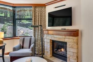 a living room with a fireplace with a tv above it at Community Perks! Everline Resort & Spa Retreat in Olympic Valley