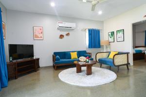 a living room with a blue couch and a tv at E' Nauwi Beach Resort in Port Vila