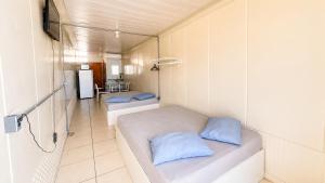 a room with two beds with blue pillows in it at Perto da Meia Praia e do Píer com Cozinha Garagem Ar Wi-Fi e Enxoval - CASA OLINDA in Porto Belo +72 photos