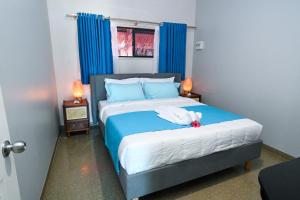 a bedroom with a bed with a stuffed animal on it at E' Nauwi Beach Resort in Port Vila +16 photos