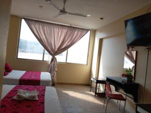 a hotel room with two beds and a flat screen tv at Hotel Resident Piura in Piura