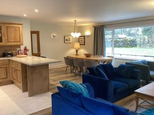a kitchen and living room with a blue couch at Tarn View in Winster