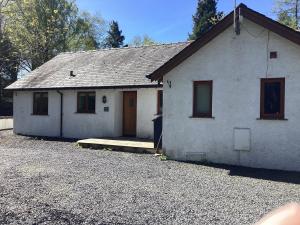 a white house with a driveway in front of it at Tarn View in Winster