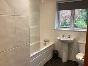 a bathroom with a tub and a sink and a toilet at Tarn View in Winster +26 photos