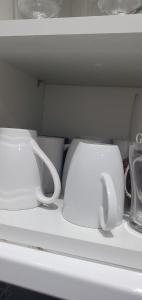 two white cups are sitting in a white refrigerator at Comfortable 2-Bed Flat with Free Parking in Paisley