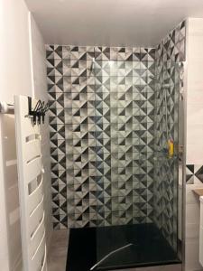 a bathroom with a shower with black and white tiles at Happy Beautiful Home in Cholet