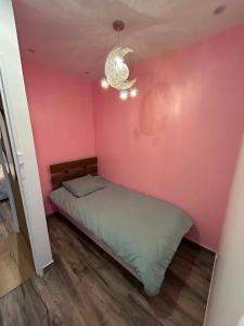a bedroom with a bed in a pink wall at Happy Beautiful Home in Cholet +4 photos