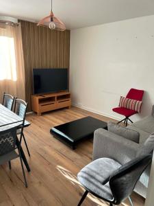 a living room with a couch and a flat screen tv at Happy Beautiful Home in Cholet