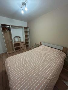 a bedroom with a bed with a striped comforter at Happy Beautiful Home in Cholet
