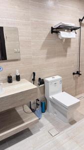 a bathroom with a toilet and a sink and a mirror at أوركيد بالاس للشقق المخدومة in Riyadh +17 photos