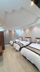a row of four beds in a room at أوركيد بالاس للشقق المخدومة in Riyadh
