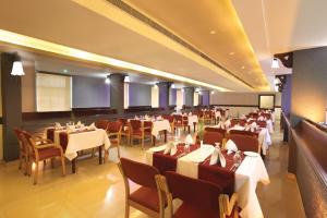 a restaurant with tables and chairs in a room at Hotel Virad in Kottakkal