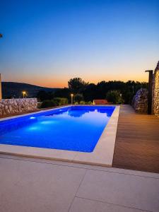 a swimming pool in a villa with a sunset at Apartment Leni in Cres