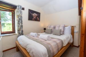 a bedroom with a large bed and a window at The Stables - Old Mill Cottages in Ilfracombe