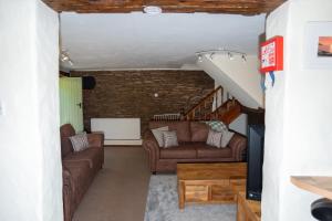 a living room with two couches and a staircase at The Stables - Old Mill Cottages in Ilfracombe +17 photos