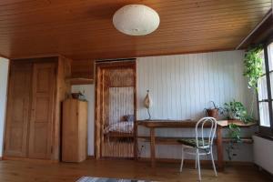 a room with a wooden ceiling with a table and a chair at Lakeview Chalet 1 , Drligen in Därligen +18 photos