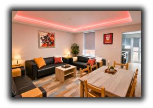 a living room with a couch and a table at The Red Lounge Rooms in Liverpool