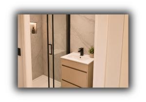 a bathroom with a sink and a shower at The Red Lounge Rooms in Liverpool