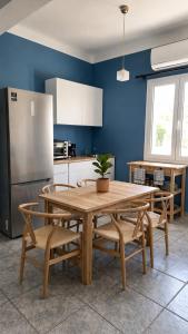 a kitchen with a table and chairs and a refrigerator at Araucaria Beachfront Residence in Finikas
