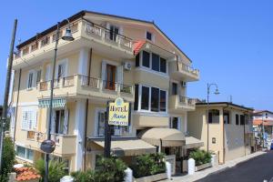 un grande edificio giallo con un cartello hotel di fronte di Hotel Maria a Castellabate