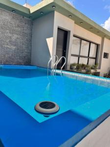 a swimming pool with a blue floor and a house at Hotel America in Victoria