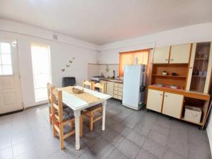 a kitchen with a table and a refrigerator at El Canto de la Ballena Loft 1 in Puerto Pirámides +11 photos