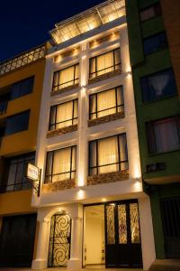 a white building with windows at night at Hotel Posada Leon in Pasto