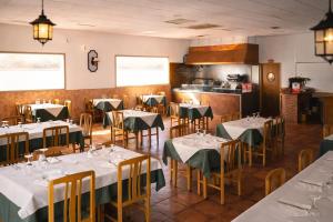 a restaurant with tables and chairs and a kitchen at Hostal la Abuela in Simancas