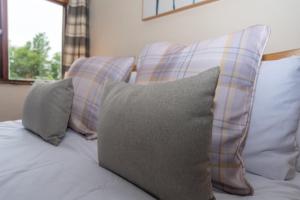 a bunch of pillows sitting on top of a couch at Treetop View - Old Mill Cottages in Ilfracombe +9 photos